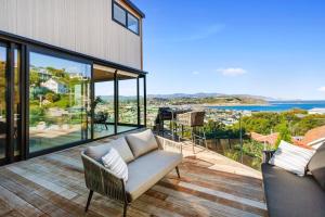 een woonkamer met een bank en uitzicht op de oceaan bij Vista Mare in Wellington