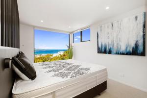 a bedroom with a bed with a view of the ocean at Vista Mare in Wellington