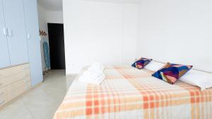 a bedroom with a bed with a orange and white blanket at Esperia Apartment by Ca-Sa Check in Chioggia