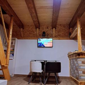 a dining room with a table and chairs and a television at Village House Djurovic in Pošćenje