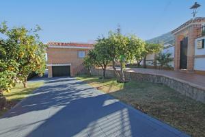 um passeio em frente a um edifício com árvores em TESS Villa Paz em Alhaurín de la Torre