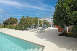 a patio with chairs and a swimming pool at TESS Villa Paz in Alhaurín de la Torre