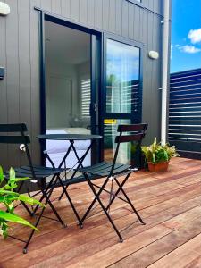 un par de sillas y una mesa en una cubierta en Wheturangi Urban Escape, en Auckland
