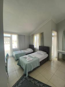 een slaapkamer met 2 bedden en een tafel. bij Nurer Apart Otel in Antalya