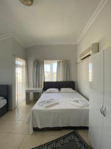 een slaapkamer met een wit bed en een raam bij Nurer Apart Otel in Antalya
