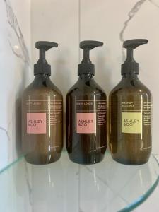 a group of four bottles of soap on a shelf at Wheturangi Urban Escape in Auckland