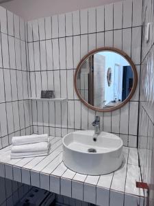 a white bathroom with a sink and a mirror at Appartement Lemaitre in Marseille