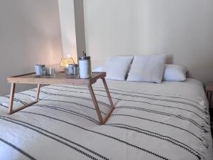 a bed with a wooden table on top of it at Appartement Lemaitre in Marseille