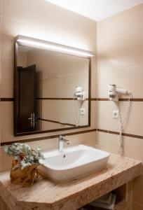 ein Badezimmer mit einem Waschbecken und einem großen Spiegel in der Unterkunft Hotel Bleske im Spreewald in Burg