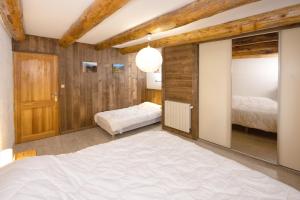 a bedroom with a large bed and a mirror at Le Chalet du Villard in Saint-André
