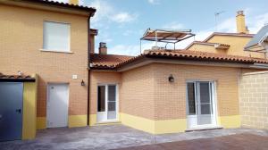 uma grande casa de tijolos com garagem em Casa Chocolate San Miguel del Pino Valladolid em San Miguel del Pino