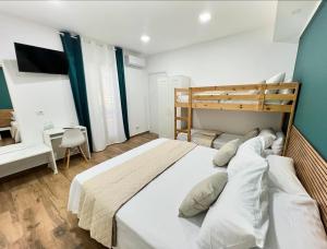 Schlafzimmer mit einem großen weißen Bett und einem Schreibtisch in der Unterkunft Easy Room in Catania