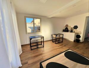 a living room with two tables and a window at Easy Room in Catania