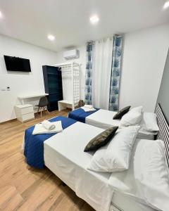 1 Schlafzimmer mit 2 Betten und einem Schreibtisch in der Unterkunft Easy Room in Catania