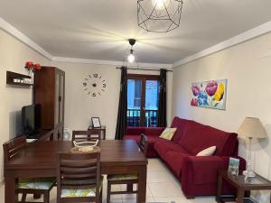 巴爾韋德的住宿－Vivienda Vacacional VillaVerde，客厅配有红色的沙发和桌子