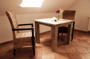 einen Tisch mit zwei Stühlen und eine Vase mit Blumen darauf in der Unterkunft urlaubsART - Ostsee - Urlaub auf Guldehof in Stoltebüll