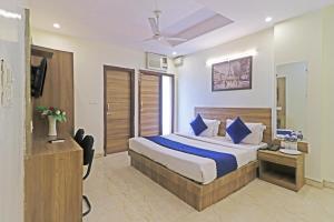 a hotel room with a bed and a television at Hotel Mint Residency - Dwarka Sector 9 in New Delhi