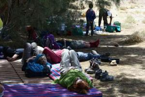 um grupo de pessoas deitadas sobre um cobertor sob uma árvore em Ouadaker amizmiz em Amizmiz
