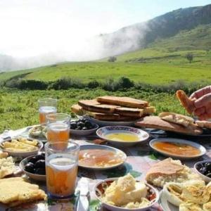 uma mesa coberta com pratos de comida em cima de um campo em Ouadaker amizmiz em Amizmiz