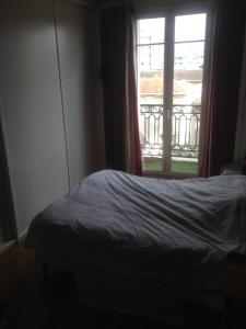 a bedroom with a bed and a window at Guest house dans appartement sur Paris in Paris +1 photo