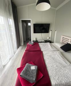 a bedroom with a large bed with a red blanket at Alexa Resort 