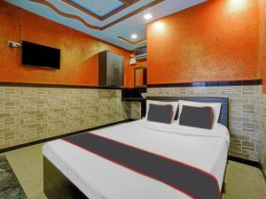 1 dormitorio con 1 cama grande y TV en la pared en Collection O Kinny Farmhouse And Resort en Dāndepāda