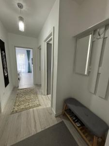 a living room with a bench and a hallway at White DeLuxe Apartment in Ploieşti