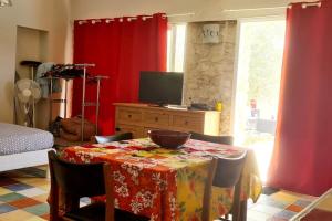 una sala da pranzo con tavolo e tende rosse di studio de 36m2, a Touvre