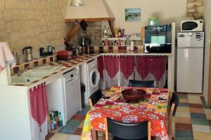 una cucina con tavolo, lavandino e piano di lavoro di studio de 36m2, a Touvre