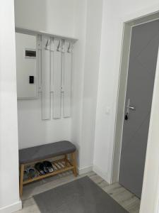 a walk in closet with a bench next to a door at White DeLuxe Apartment in Ploieşti