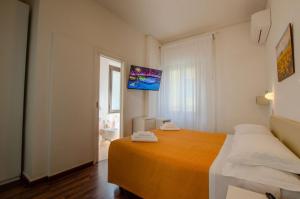 sypialnia z łóżkiem i telewizorem na ścianie w obiekcie Hotel Del Buono Wellness & Medical Spa w mieście Chianciano Terme
