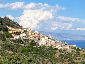 uma aldeia no topo de uma colina perto do oceano em Casa zia Vincenzina em Casalvecchio Siculo