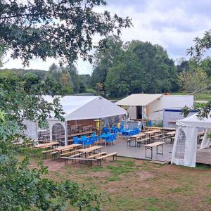 a group of tables and white tents with blue chairs at Tente Lodge Safari - La Plage Autet in Autet