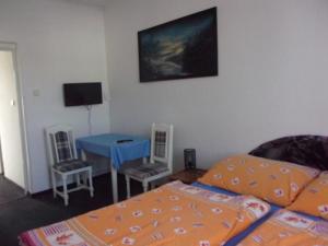 1 dormitorio con 1 cama, mesa y sillas en Penzion No1, Mariánské Lázně, en Mariánské Lázně