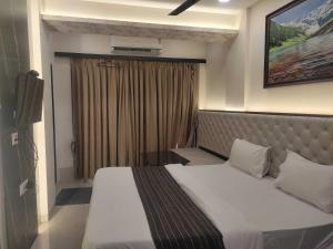 a hotel room with a bed and a window at Hotel O MAIREAD in Sopāra