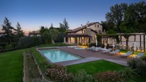 a backyard with a swimming pool and a house at Villa Pergola by Palazzo di Varignana in Varignana