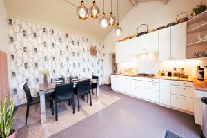 uma cozinha com armários brancos e uma mesa e cadeiras em Lets Relax - Coté Nature em Mons