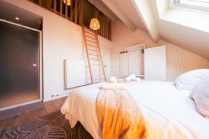 Un dormitorio con una gran cama blanca y una escalera en Lets Relax - Coté Nature, en Mons