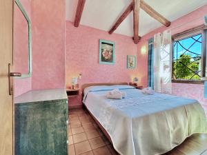 1 dormitorio con paredes rosas, 1 cama y ducha en Vistamare Villetta A Schiera, en Baja Sardinia