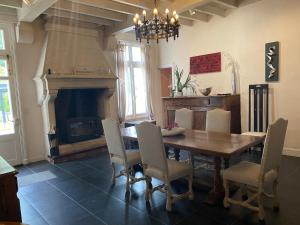 uma sala de jantar com uma mesa e uma lareira em Domaine de la Perthuiserie em Saint-Porchaire