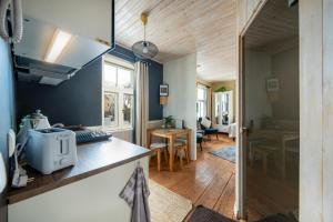 cocina con paredes azules y suelo de madera en Garden Studio next to Telliskivi & Old Town en Tallin