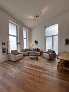 una gran sala de estar con sofás y una mesa. en Großzügige Wohnung in der Nähe vom Quartierpark en Hamburgo