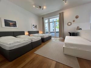 Habitación grande con 3 camas y ventana. en Großzügige Wohnung in der Nähe vom Quartierpark en Hamburgo