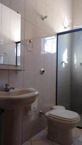 ein Bad mit einem Waschbecken, einem WC und einer Dusche in der Unterkunft Hotel Brasil Real in Mariana