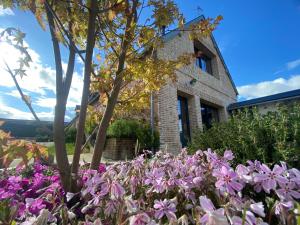 un giardino di fiori di fronte a un edificio di LA LONGERE GALOPE a Sainte-Gauburge-Sainte-Colombe