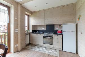 a kitchen with wooden walls and a white refrigerator at Appartamento Merida6 - Asiago in Asiago