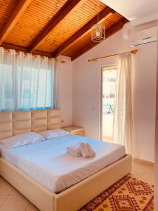 een slaapkamer met een groot bed voor een raam bij Inara's apartment in Sarandë