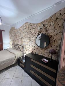 ein Schlafzimmer mit einer Steinmauer und einem Spiegel in der Unterkunft Villa Azzurra Fronte Mare in Capitana