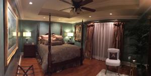 - une chambre avec un lit et un ventilateur de plafond dans l'établissement Louisiana Cajun Mansion, à Youngsville