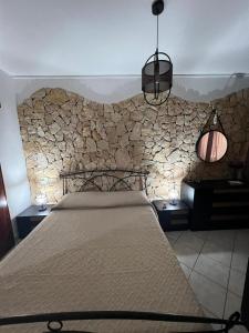 ein Schlafzimmer mit einem Bett und einer Steinmauer in der Unterkunft Villa Azzurra Fronte Mare in Capitana